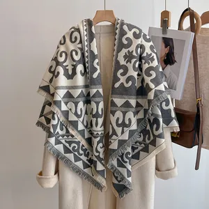 Détail d'un châle rétro à motif ethnique avec franges sur un manteau de laine
