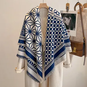 Detail eines marineblauen Kaschmir-Schals mit geometrischen Mustern und eleganten Fransen