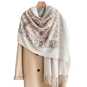 Beige floral embroidered cashmere-feel pashmina shawl with tassel fringe on a coat