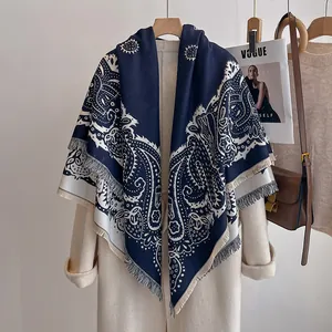 Gros plan sur le motif cachemire bleu foncé et les franges d'un châle d'hiver doux