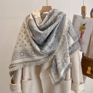 Écharpe bohème classique style cachemire à motifs paisley et franges sur un manteau beige