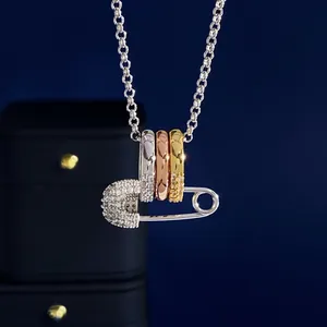 Dreifarbige Halskette mit ineinandergreifenden Ringen und glitzerndem Sicherheitsnadel-Anhänger