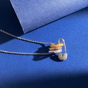 Detailansicht dreifarbiger Ringe an Sicherheitsnadel-Anhänger mit Zirkonia und Silberkette