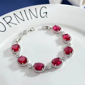 Sparkling silver bracelet featuring oval red gemstones and floral cubic zirconia clusters