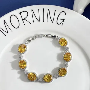 Macro shot of silver bracelet with oval yellow gemstones and zircon floral halo detailing