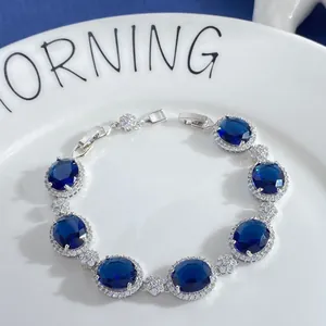 Macro detail of silver oval sapphire zirconia bracelet on a white ceramic plate