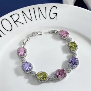 Detailed shot of halo-set oval pink, purple, and yellow gemstones on a silver bracelet