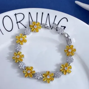 Detailed shot of floral zircon bracelet with yellow flowers on a white plate