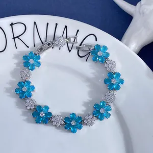 Macro detail of silver floral bracelet with blue petals and sparkling zircon accents