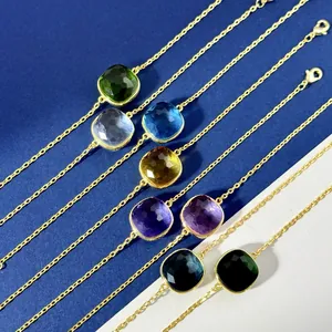Detailed view of colorful cushion-cut gemstone bracelets with golden lobster clasp chains