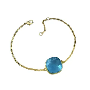 Golden chain bracelet featuring a square faceted blue crystal with lobster clasp closure