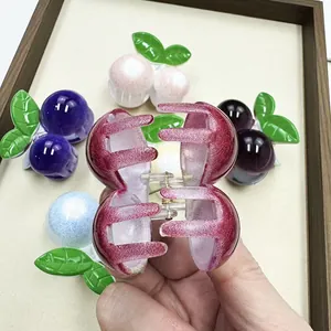 Primer plano de pinzas para el cabello de cereza con purpurina en varios colores y hojas