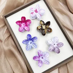 Dettaglio di 6 mollette per capelli a forma di fiori colorati su tessuto di seta elegante