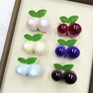 Pinzas para el pelo de cereza brillantes en seis colores con hojas verdes sobre beige