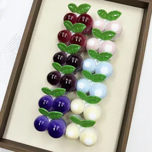 Primer plano de 6 pinzas para el cabello de cereza de colores con hojas sobre fondo beige