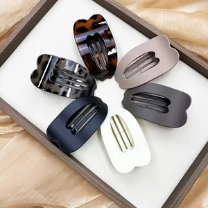 Flat oval hair claw clips set in six assorted colors displayed on silk fabric