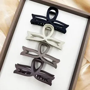 Set of four matte hollow bow hair claws in black, beige, and brown for women