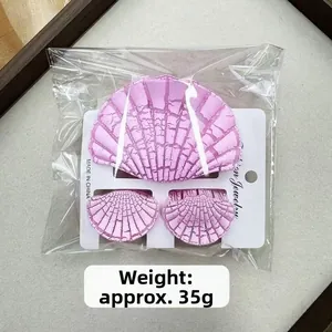Dettaglio di set mollette per capelli viola a conchiglia su scheda di presentazione moda