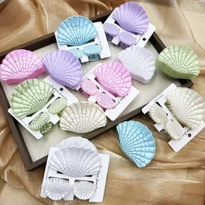 Set di fermagli per capelli a conchiglia color macaron su elegante seta color oro