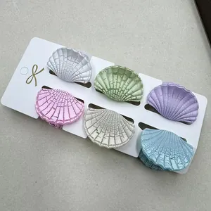 Set dettagliato di sei mollette a forma di conchiglia in toni pastello su carta
