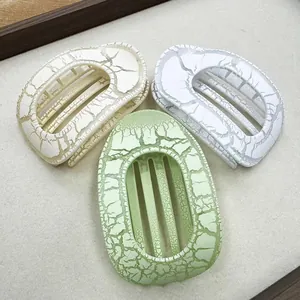 Detailed view of three oval hair claws with a unique crackle pattern finish