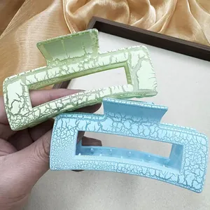 Détail de grandes pinces à cheveux carrées vert clair et bleu avec texture craquelée