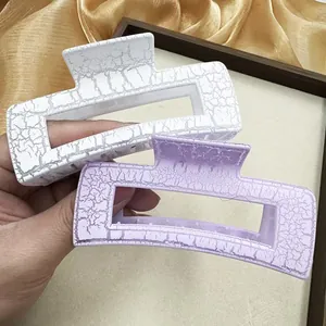 Détail de grandes pinces à cheveux carrées avec texture craquelée élégante en blanc et violet