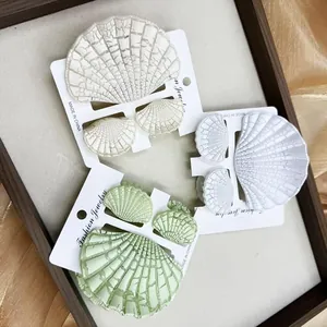 Dettaglio del set di tre fermagli per capelli a conchiglia con texture effetto crepato