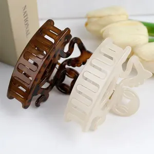 Detail of tortoise shell and cream claw clips with circular hollow design for hair