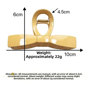 Detailed view of yellow bow-shaped hair claw clip with dimensions and spring mechanism