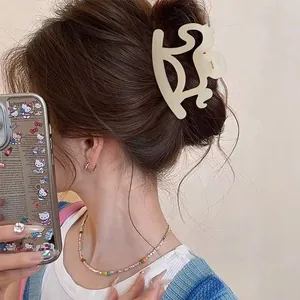 Cream-colored cute puppy hair claw clip shown on a bun hairstyle for women