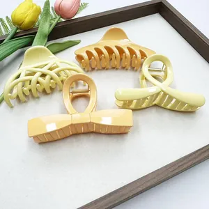 Set of four large matte hollow hair claw clips in warm yellow and orange tones