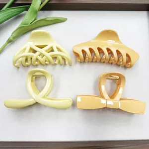 Set of minimalist cutout claw clips in yellow and orange tones on a textured background
