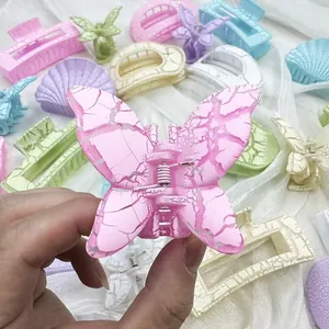 Dettaglio di fermagli per capelli a fiore con trama increspata e toni macaron