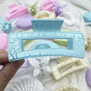 Dettaglio di fermagli per capelli con texture screpolata e motivi a farfalla