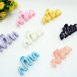 Set di mollette per capelli ondulate in sette colori su una superficie bianca