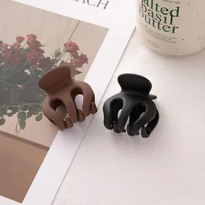 Grandes pinces à cheveux mates marron et noires pour cheveux épais sur fond esthétique