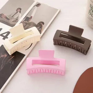 Trois grandes pinces à cheveux carrées mates en crème, café et rose sur une table blanche