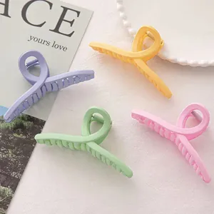 Dettaglio di grandi mollette per capelli opache in viola, giallo, verde e rosa pastello