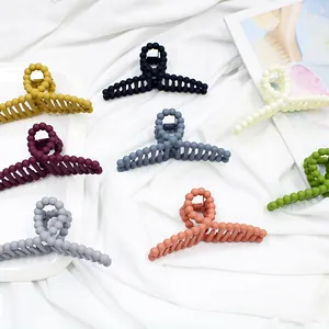 Macro detail of large matte hair clips with unique beaded design in various pastel colors