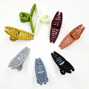Flat lay of matte finish hair claw clips in seven diverse candy colors on white background