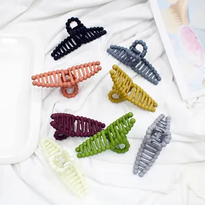 Detailed view of matte hair claws in 7 vibrant colors on a soft white fabric background