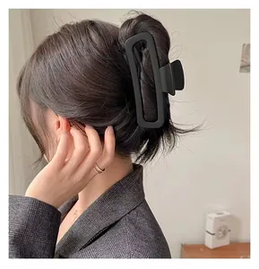 Détail d'une grande pince à cheveux rectangulaire noire mate portée par un mannequin