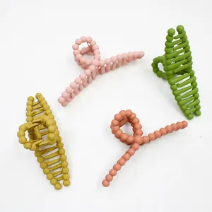 Detail of four matte beaded twist hair claws in Morandi colors with metal springs