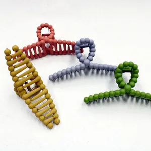 Detail view of large matte candy-colored hair claw clips in four assorted pastel colors