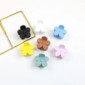 Set of seven matte flower hair claw clips in assorted colors on a white background