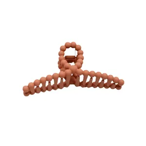 Matte brick red hair claw clip with unique round ball chain design on white background