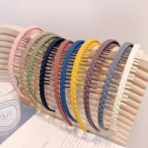 Cerchietti colorati antiscivolo con trama intrecciata e denti esposti su supporto in legno