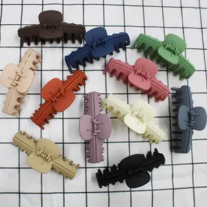 Lot de 11 pinces à cheveux mates de différentes couleurs sur fond à carreaux
