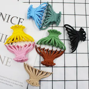 Flat lay of matte candy-colored claw clips in various Morandi tones on a mesh backdrop